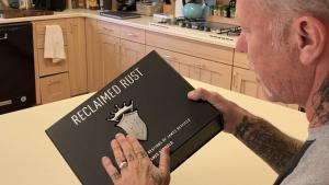Regardez James Hetfield de Metallica feuilleter son livre Reclaimed Rust