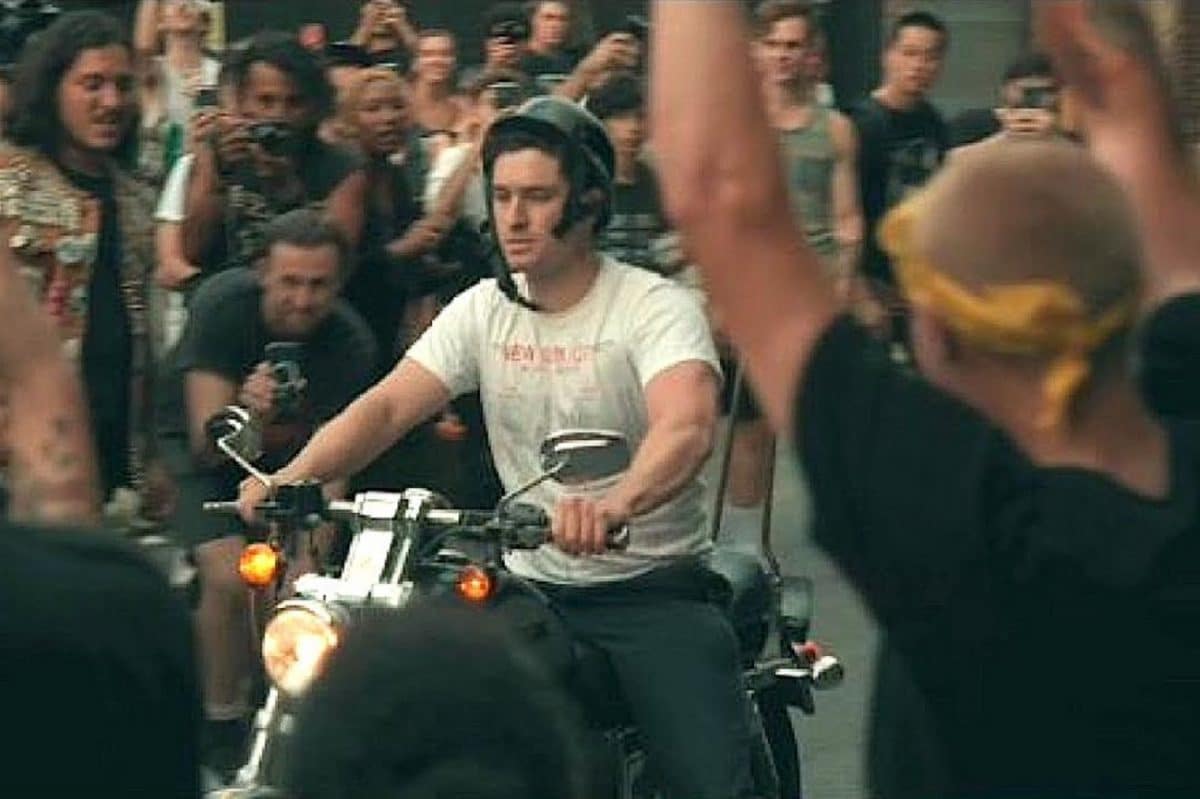 Un homme sur une moto entre dans la fosse d&rsquo;un concert Punk en plein air