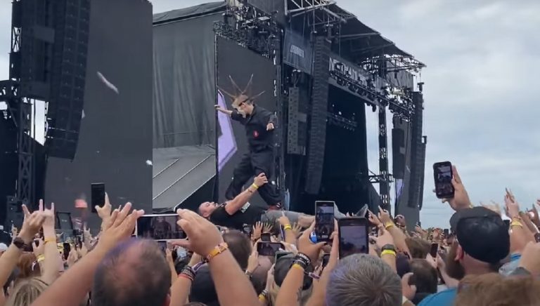 Un enfant en costume Slipknot fait du crowd surfing sur le ventre de son père lors d’un récent festival de Metal